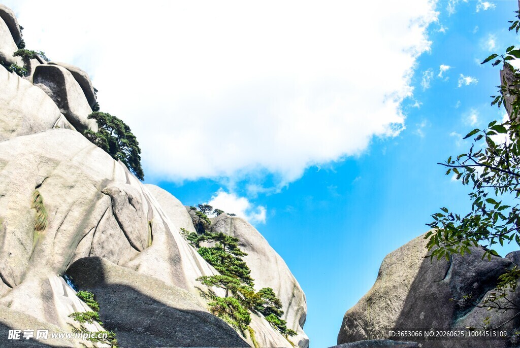 巍峨山石间的蓝天绿树