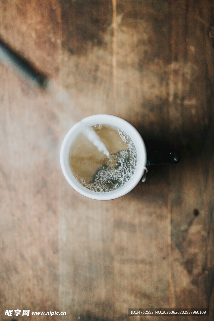 木桌上的一杯泡着茶包的茶