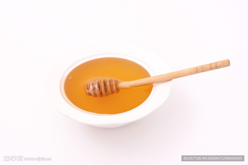 碗中蜂蜜与木质搅拌棒