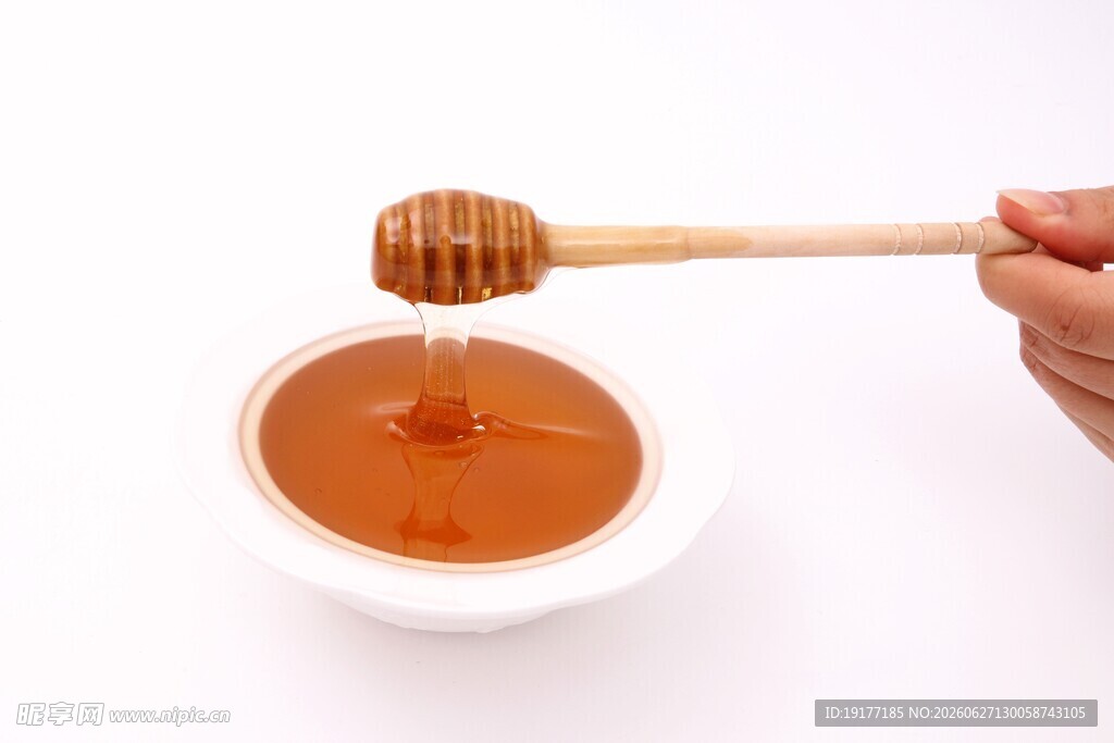 木勺舀蜂蜜于白碗中