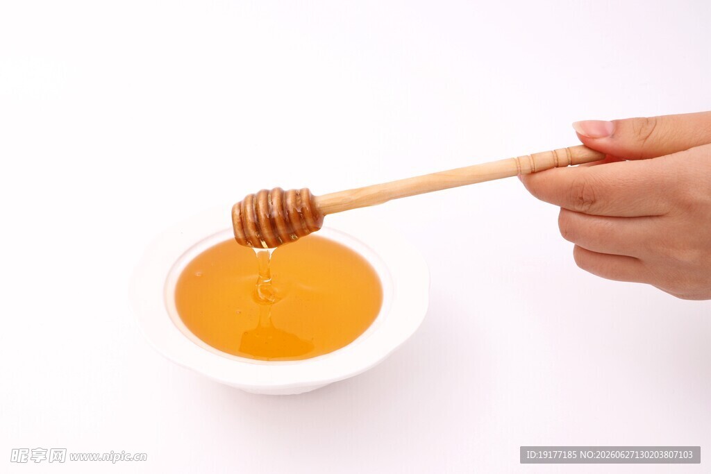手持木勺舀取碗中蜂蜜
