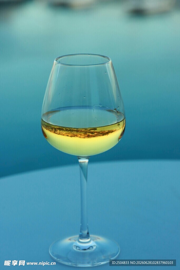 蓝色桌面上的一杯白葡萄酒