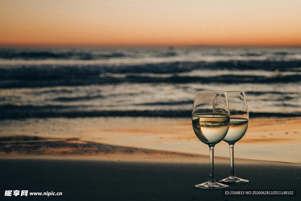 海边夕阳下的两杯白葡萄酒