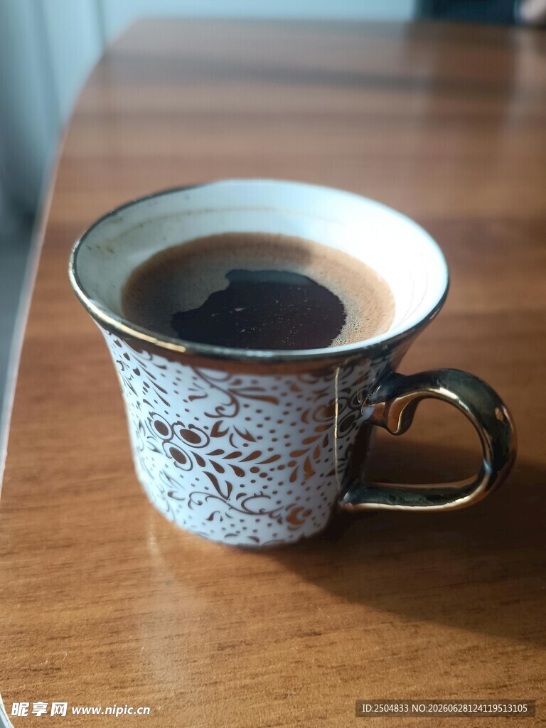 复古花纹杯中的棕色饮品