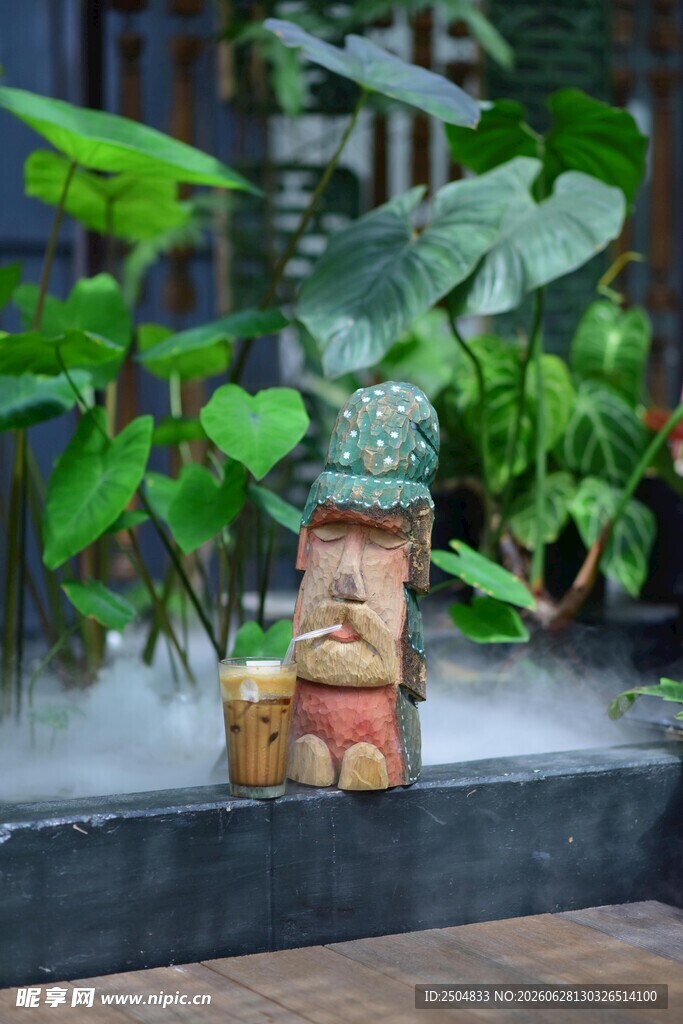 户外绿植旁的可爱小雕像