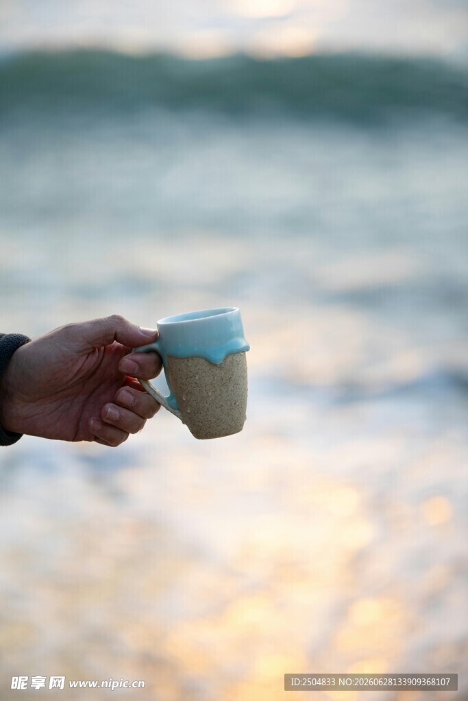 海边手持咖啡杯的惬意瞬间