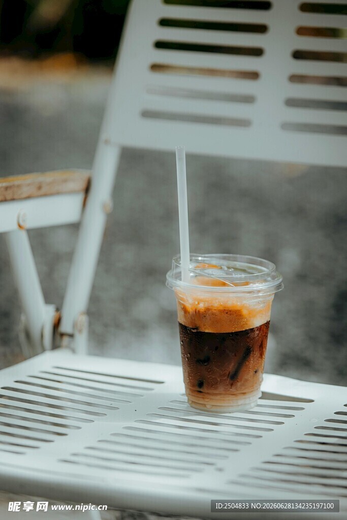 户外白椅上的一杯冰咖啡
