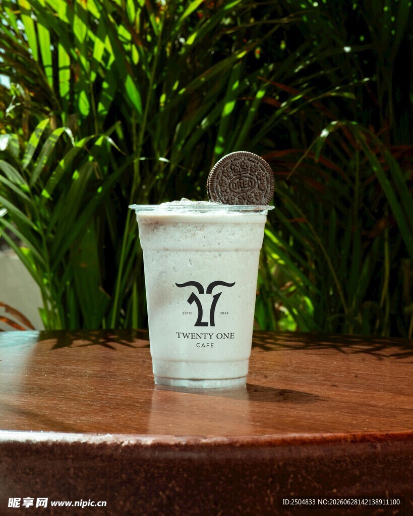 透明杯中的饮品与绿植背景