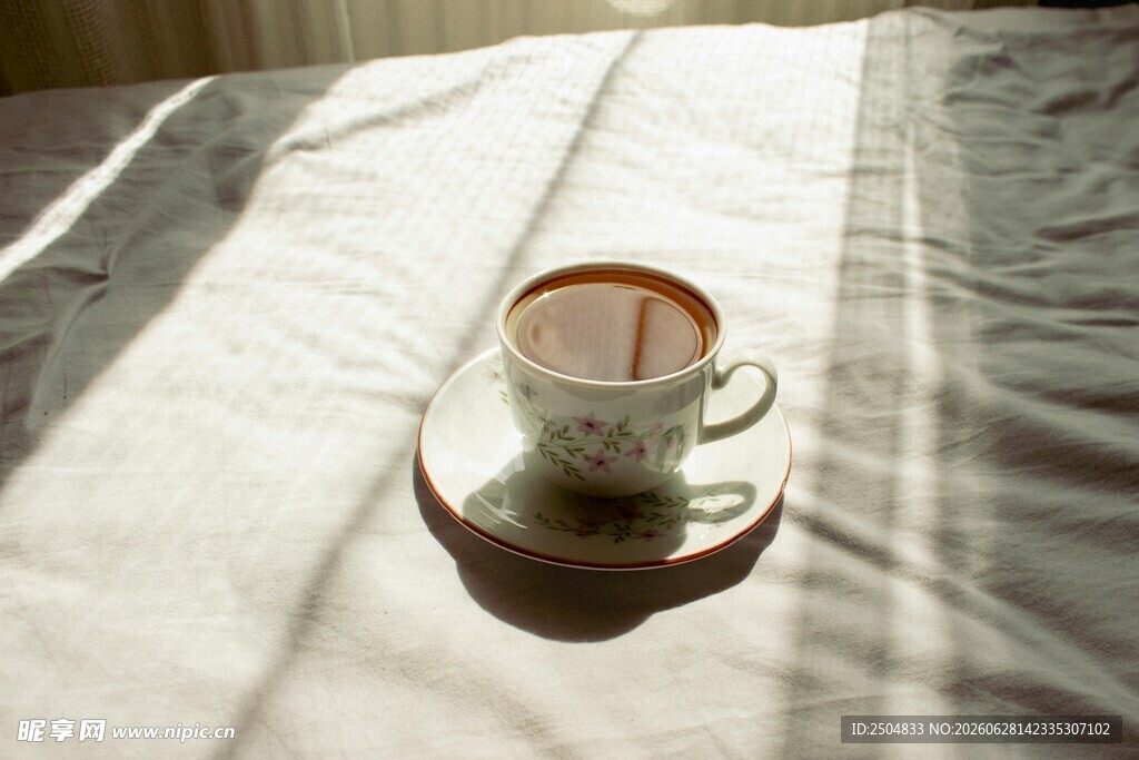 阳光下床铺上的雅致茶杯