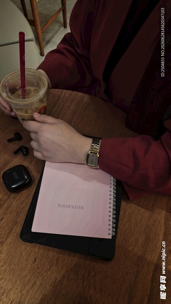 桌边手持饮品书写的场景