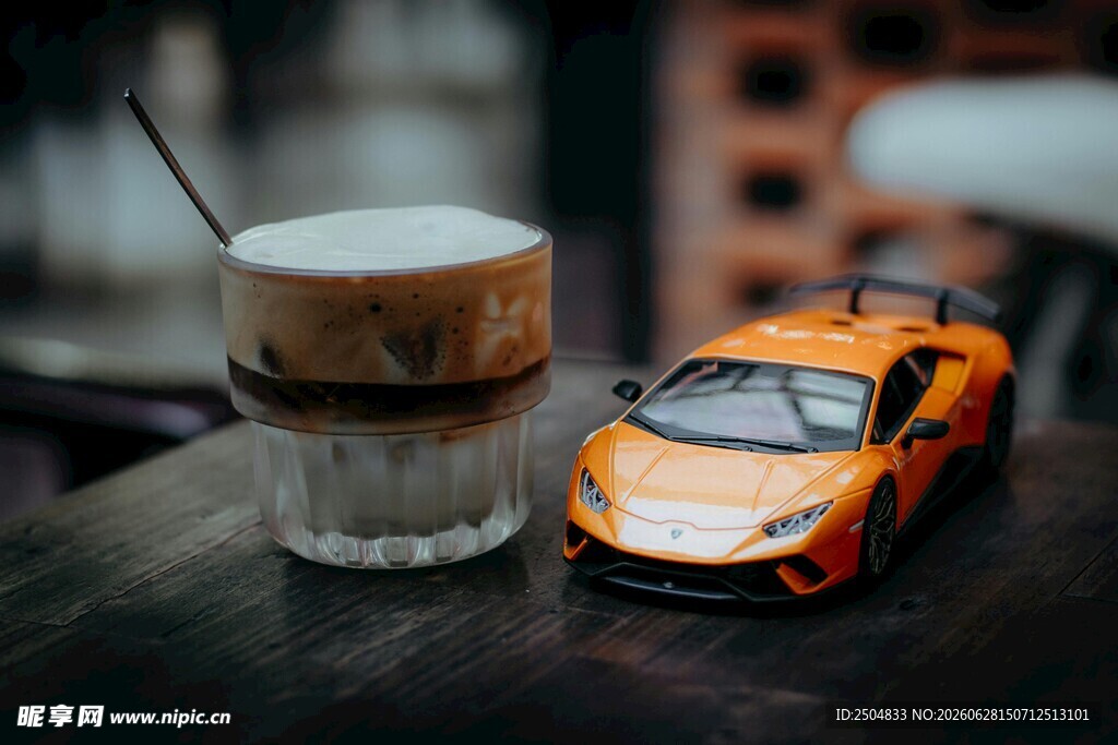 咖啡旁的橙色玩具跑车