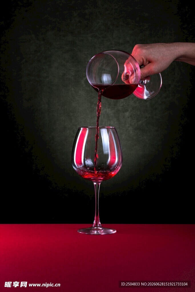 手倾红酒入高脚杯