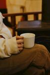 手捧白杯享受静谧时光
