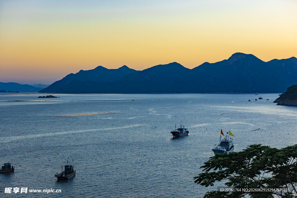 海上暮色中渔船与远山