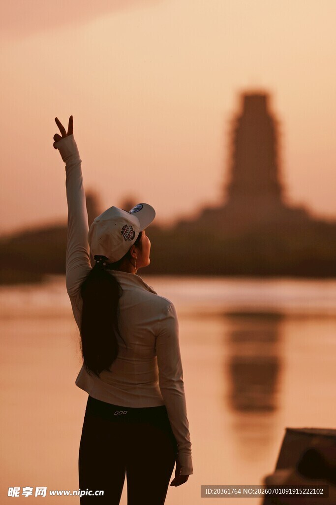 夕阳下女子抬手望向远方