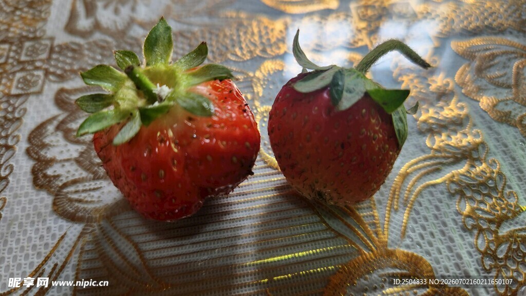 两颗鲜红草莓摆于桌