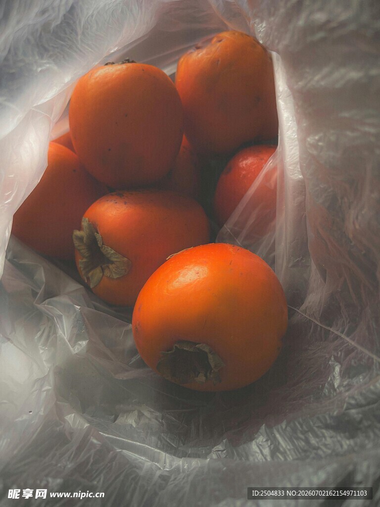 袋装新鲜诱人的橙色柿子