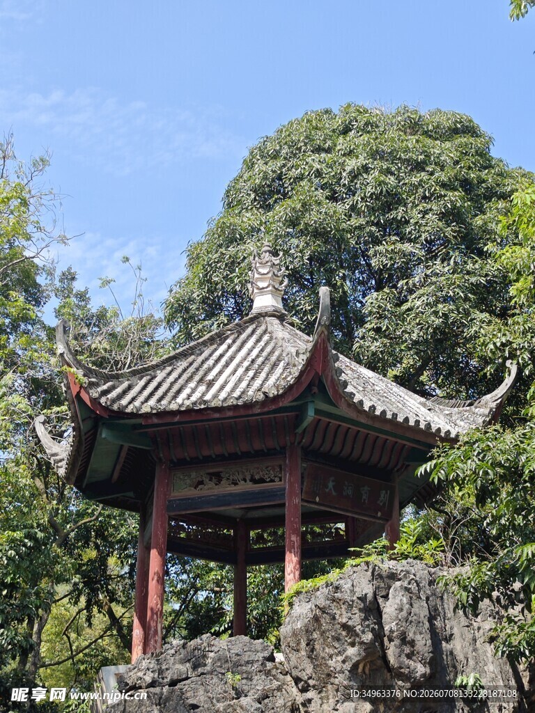 中式古亭立于山石绿树间