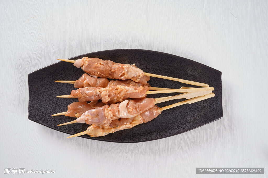 美味鸡肉串摆放在黑盘上