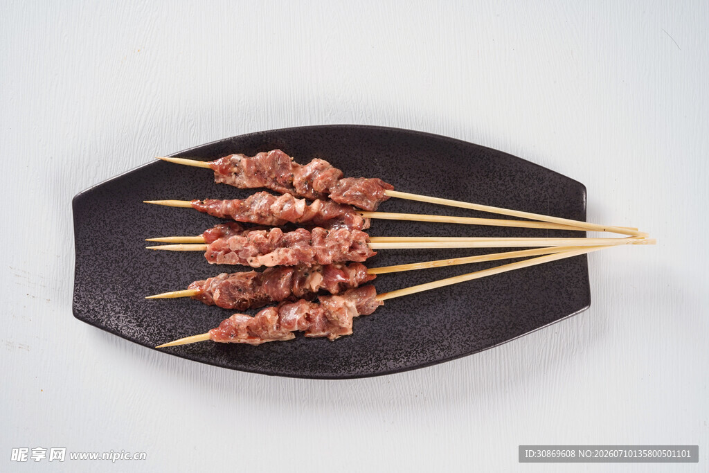 美味羊肉串摆于黑色盘上