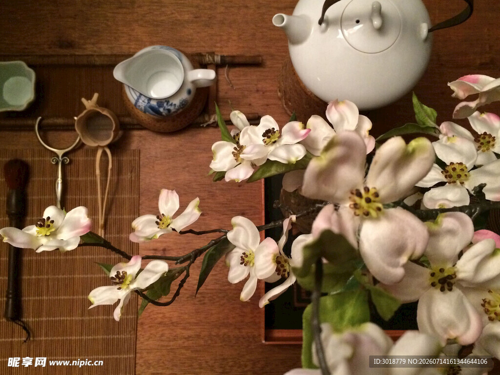 中式茶具旁的素雅花枝
