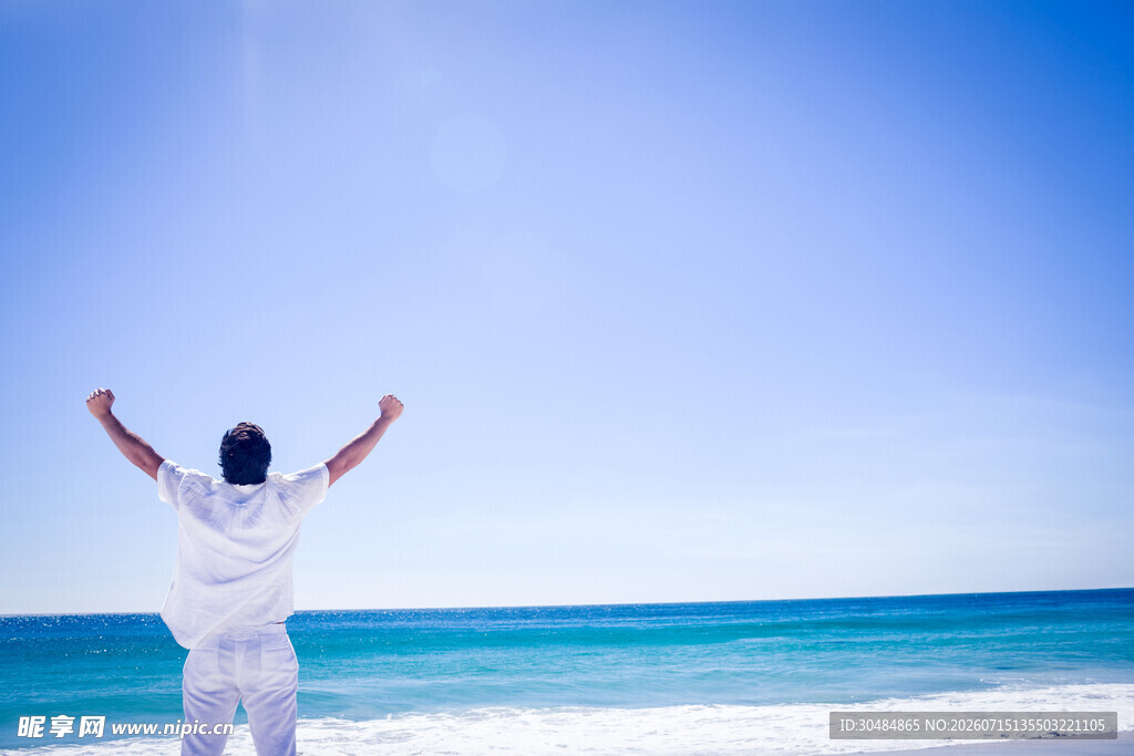 海边男子张开双臂迎海风