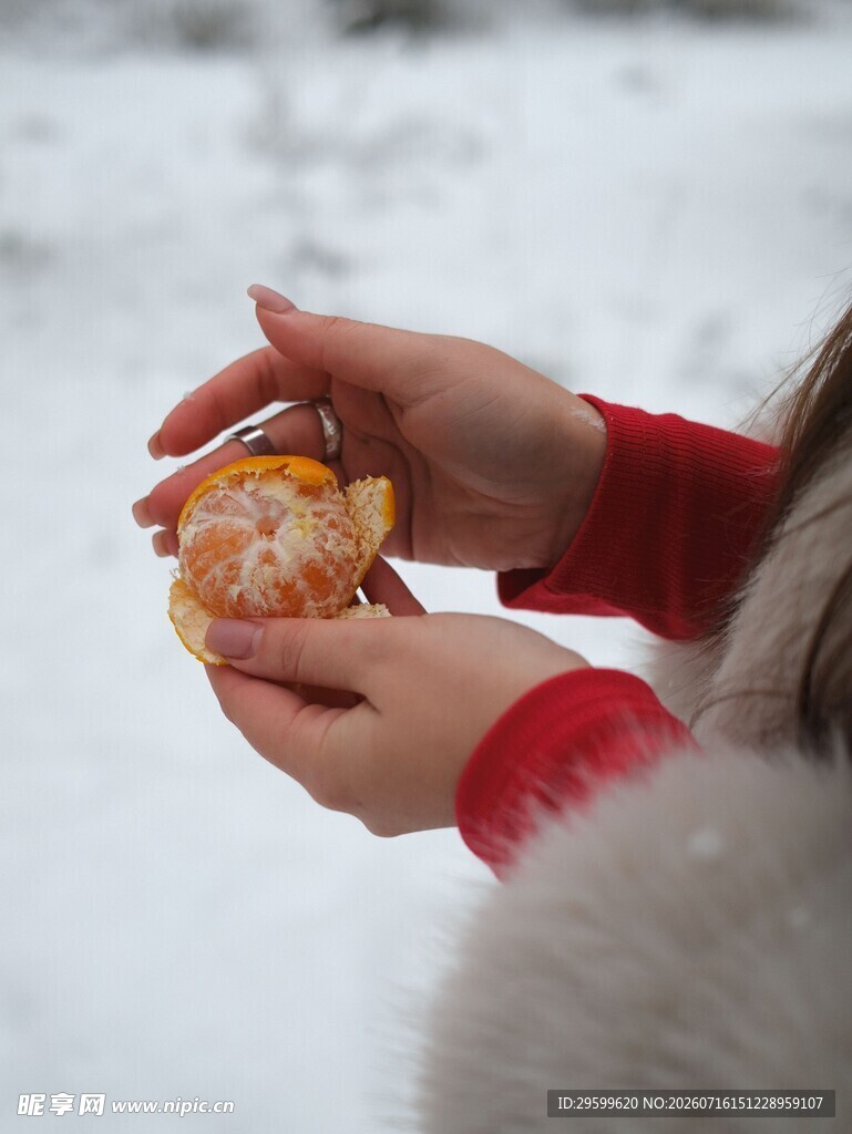 雪地中双手剥橘子画面