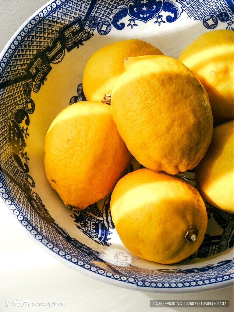 蓝白瓷碗中的鲜黄柠檬