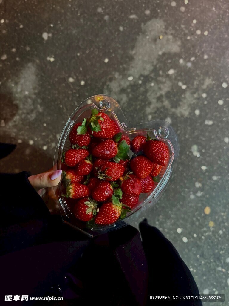 手捧心形盒中的新鲜草莓