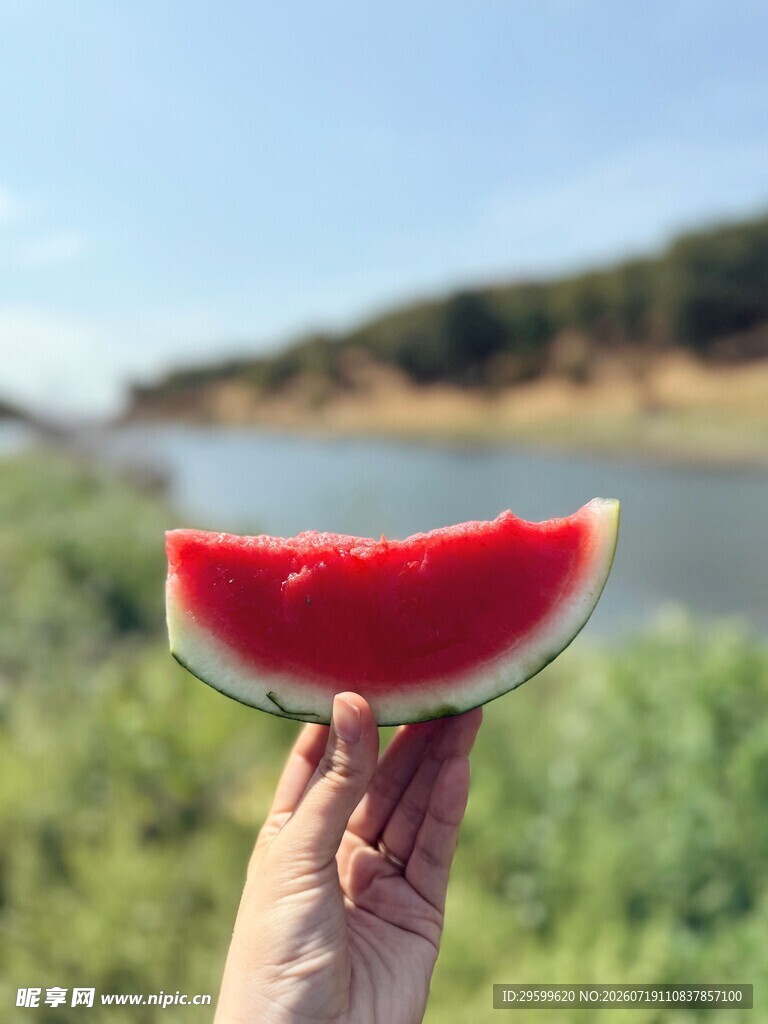 手举鲜切西瓜赏湖景