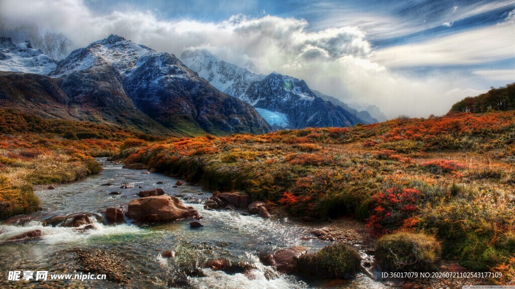 山间溪流旁的壮丽雪山景色