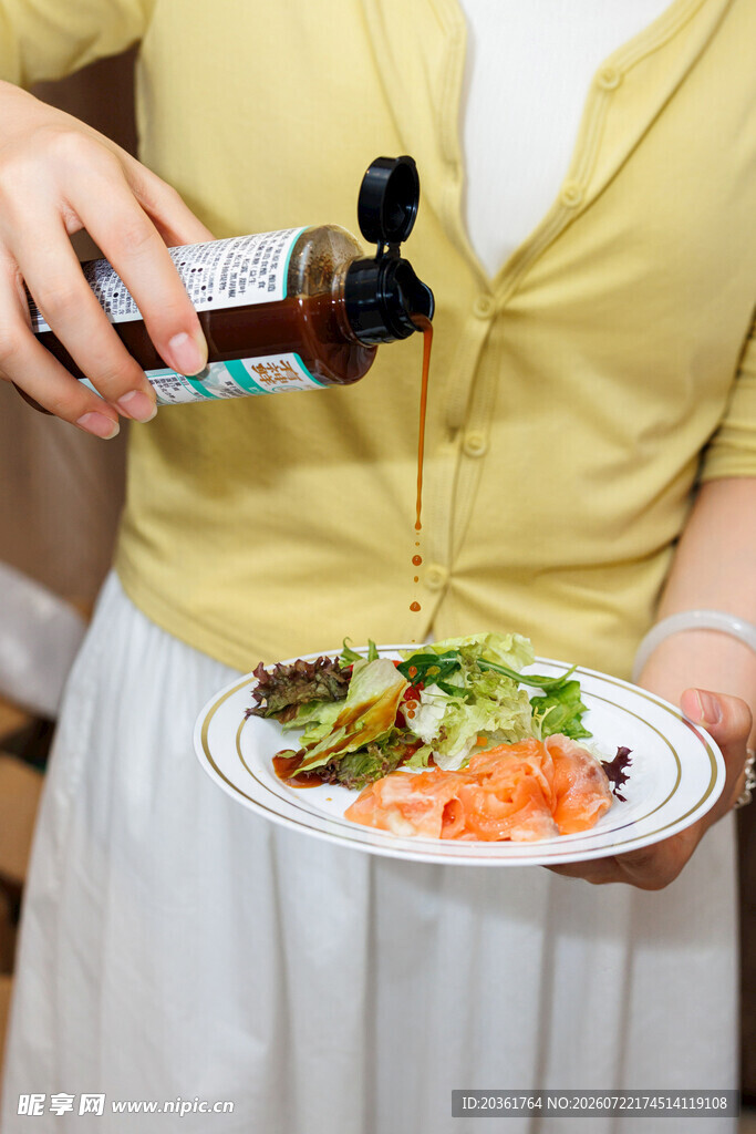 女士为美食浇淋调味汁