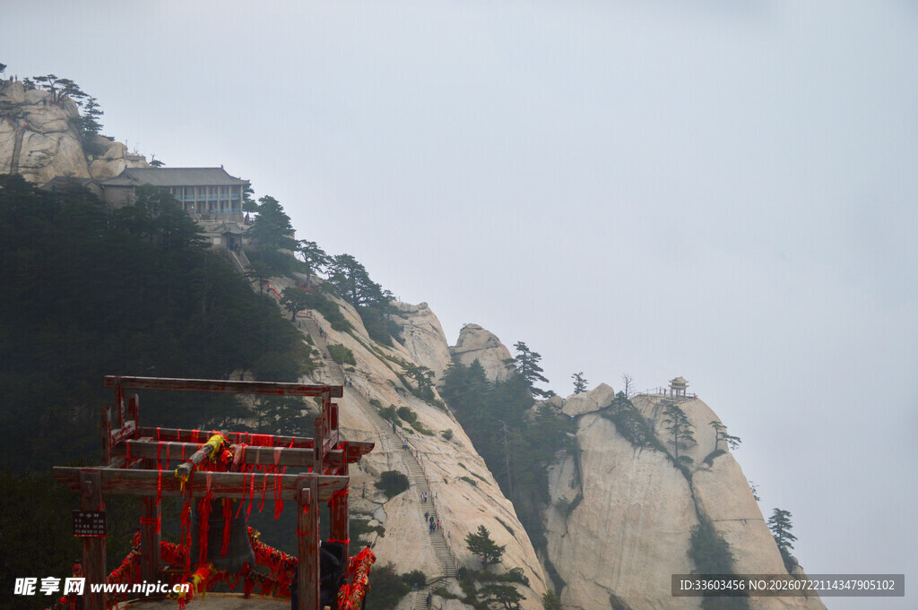 险峻山峰下的红色建筑