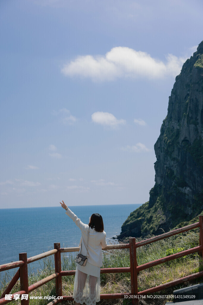 海边女子舒展双臂赏美景