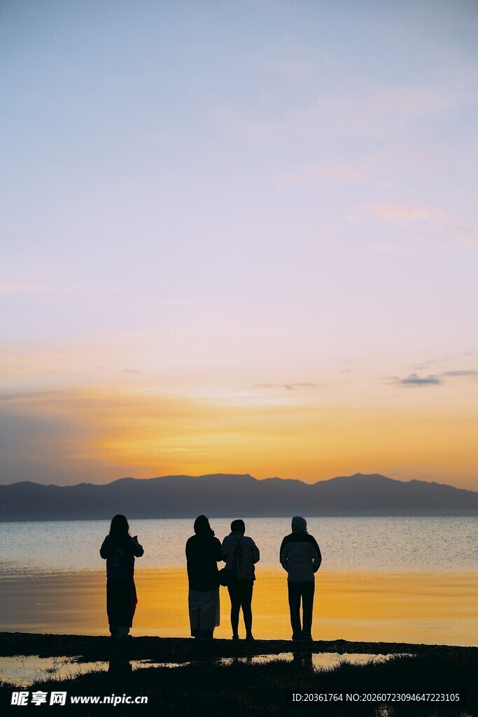 夕阳下的海边人群剪影