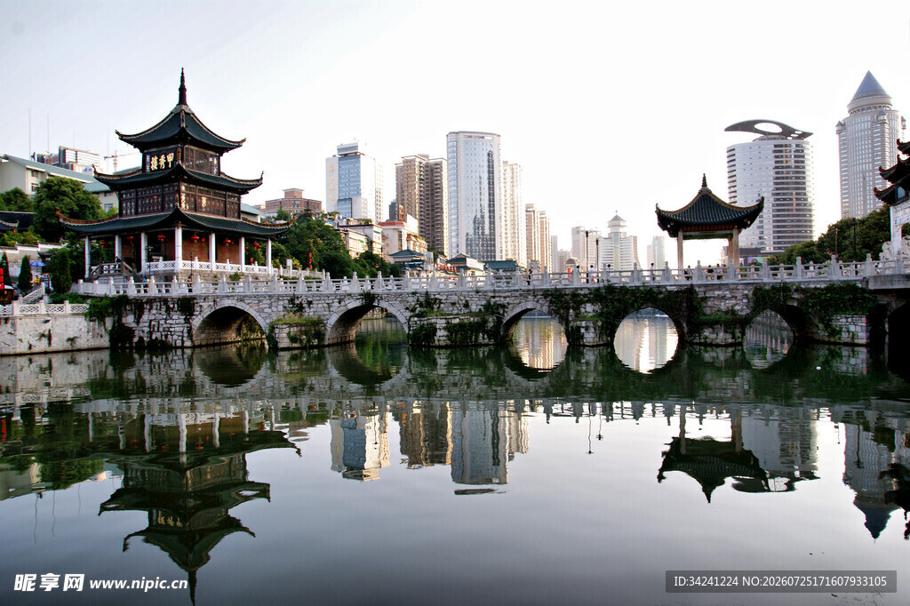 中式古桥映于城市湖景中