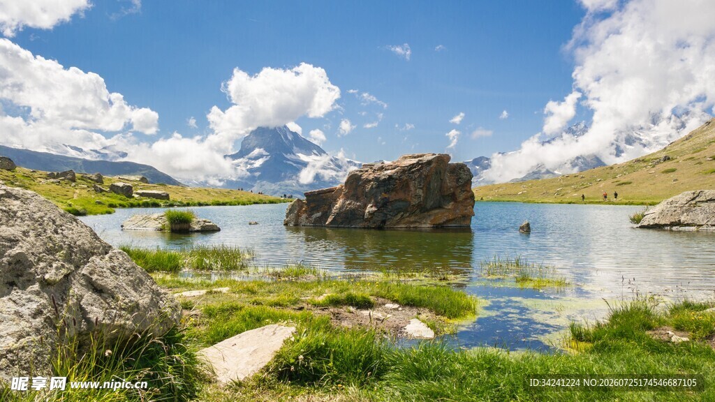 湖畔巨石与蓝天绿草美景