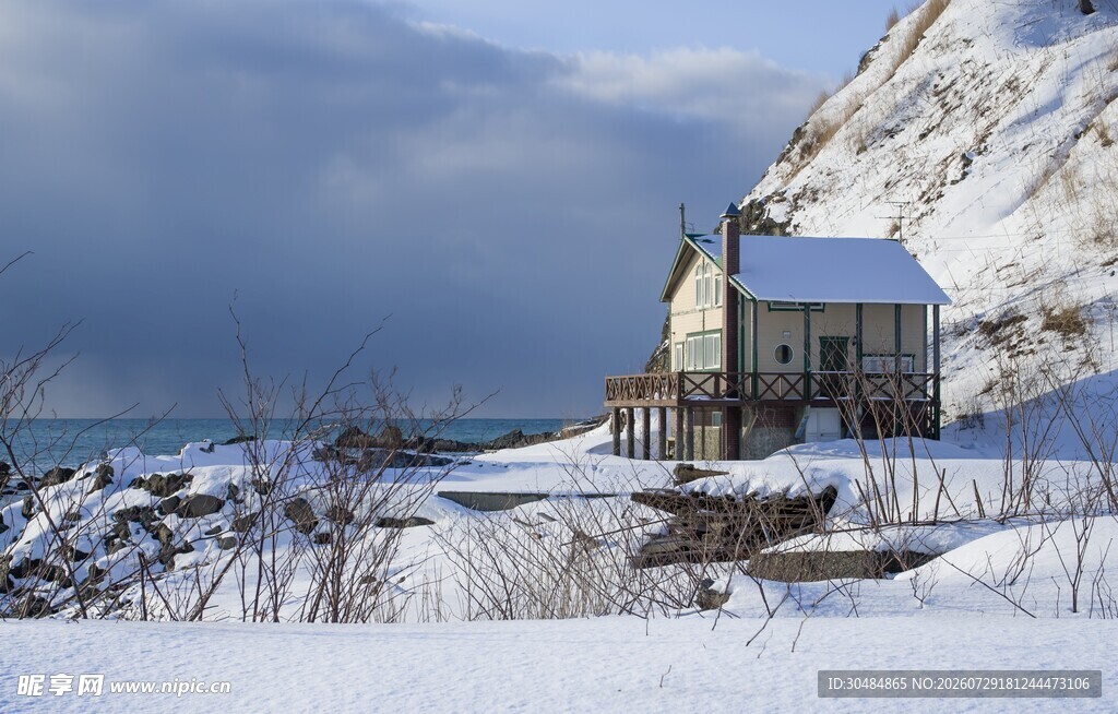 雪覆海岸边的温馨小屋