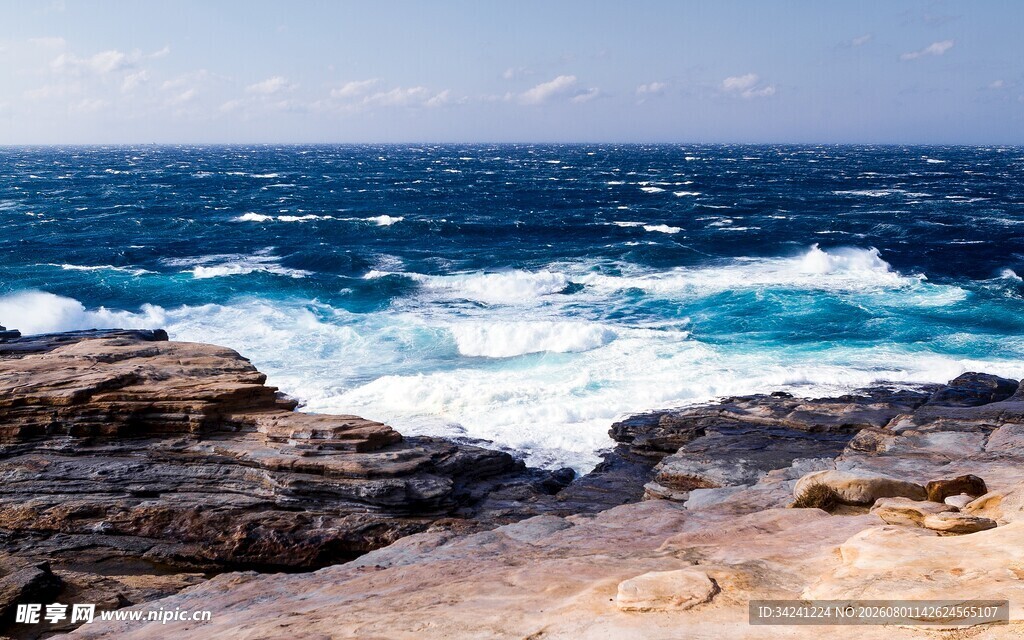 海边礁石与翻涌的蓝色海浪
