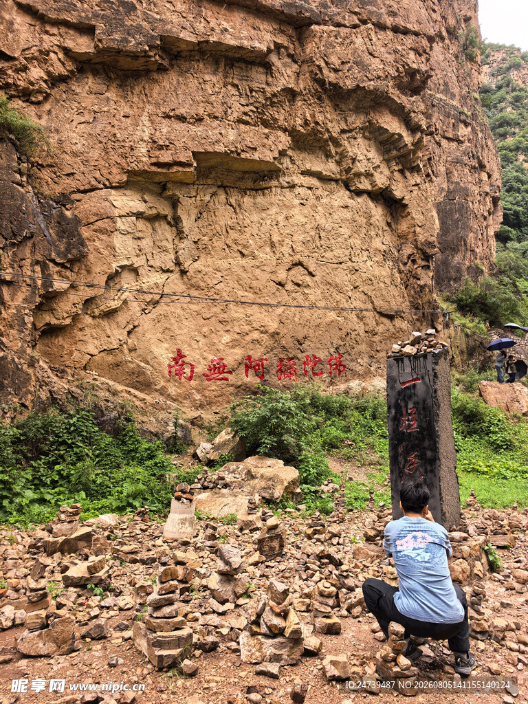 人在岩壁下观察地质景象