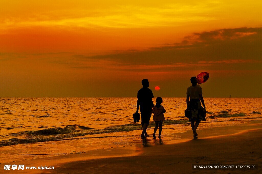 夕阳下海边漫步的幸福家庭
