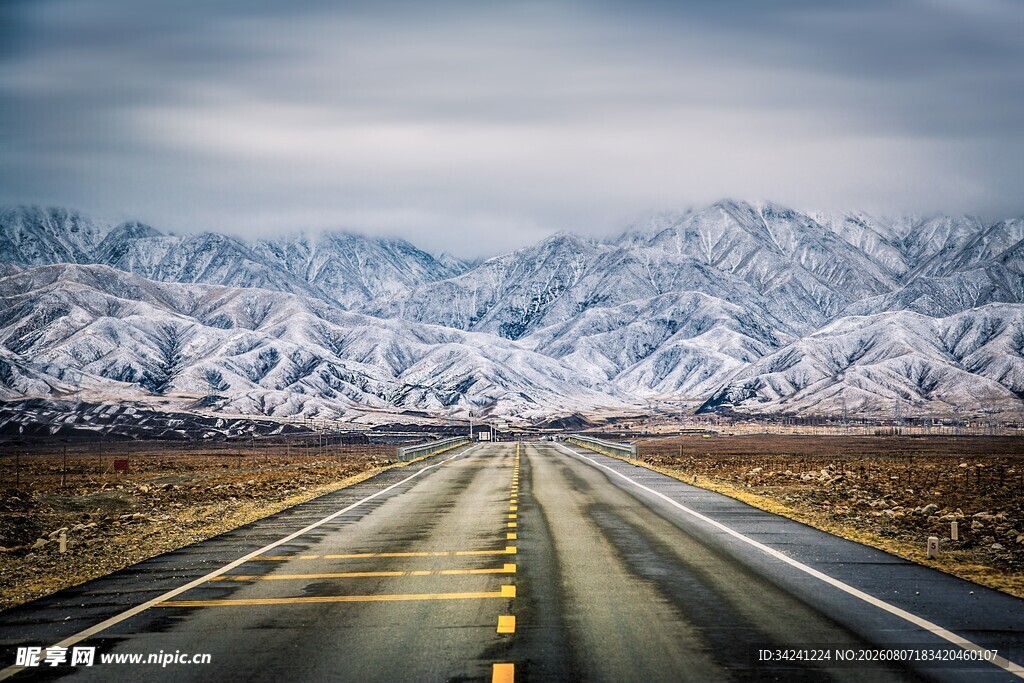雪覆远山旁的空旷公路