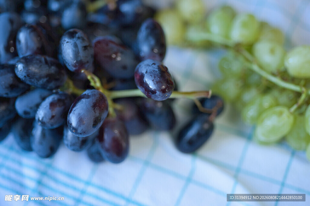 紫绿葡萄摆于格子布上