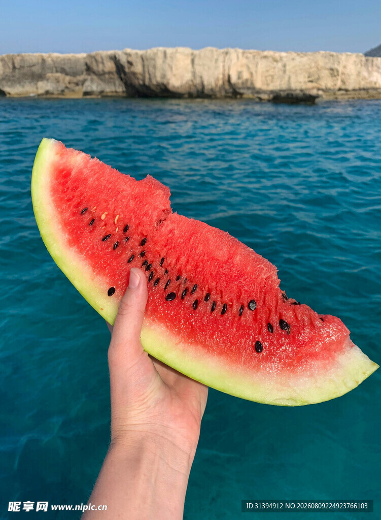 海边手持西瓜的惬意瞬间