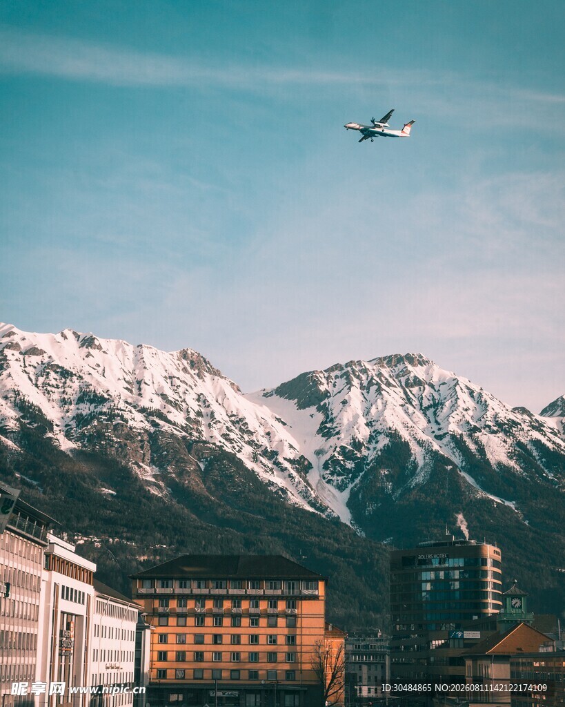 雪山城市上空的飞行飞机