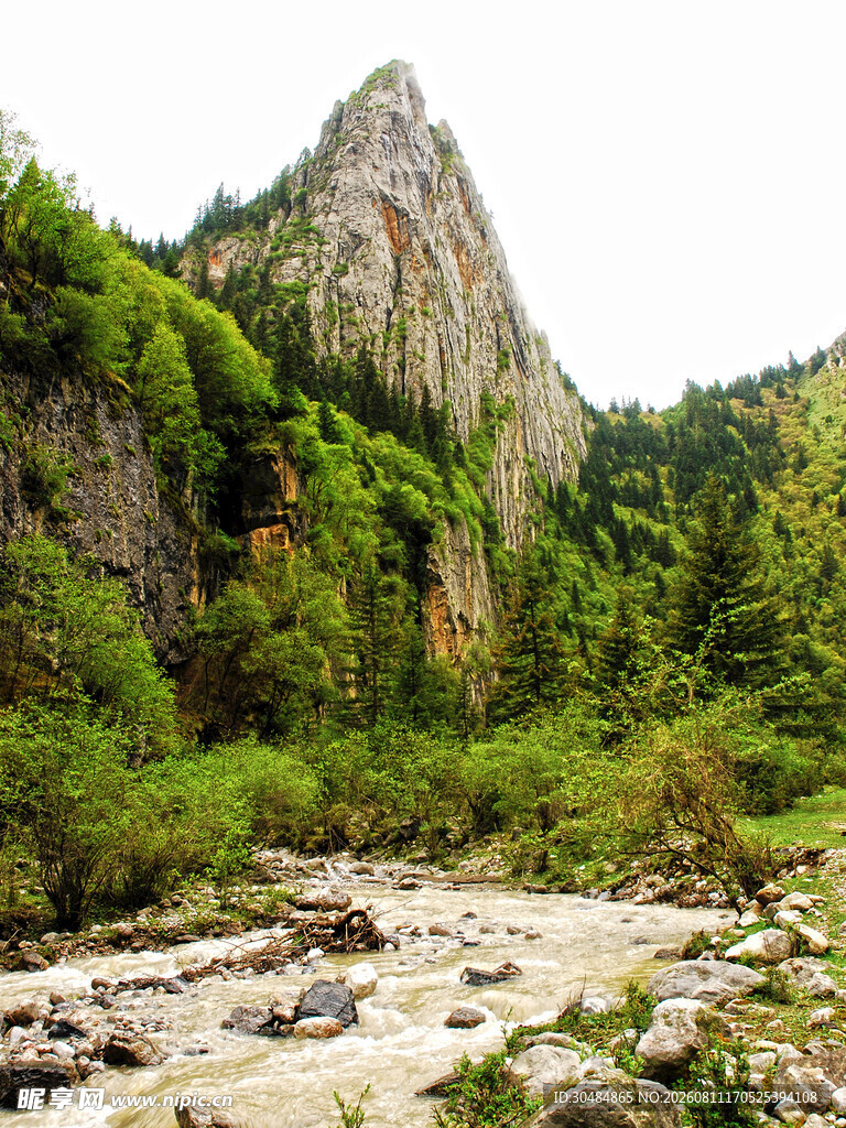 山间溪流旁的葱郁峻峭山峰