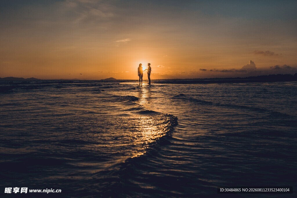 夕阳下海边漫步的浪漫身影