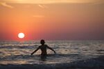 夕阳下海中漫步的身影