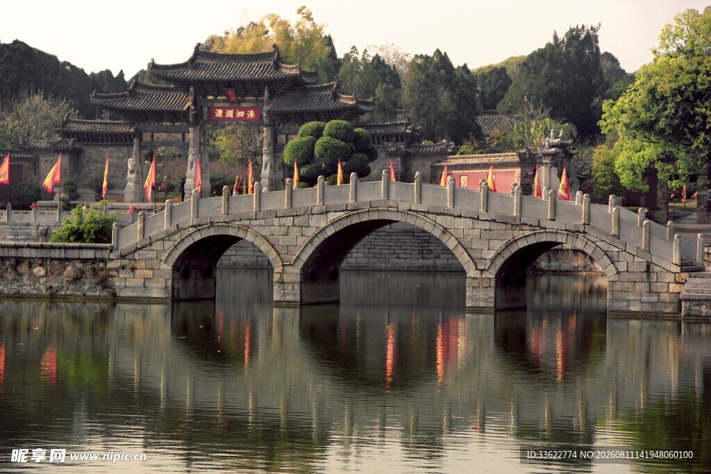 古桥映于中式建筑旁湖水