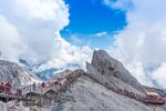 巍峨雪山栈道上的游客